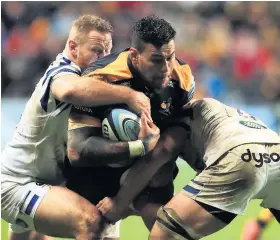  ?? Picture: Mike Egerton/PA ?? Wasps’ Nathan Hughes is tackled by Bath’s Ross Batty, left, and Francois Louw during Saturday’s European Champions Cup game at the Recreation Ground