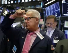  ?? Richard Drew/ Associated Press ?? Executive Floor Governor Rudy Mass works with traders on the floor of the New York Stock Exchange on Monday. Stocks dropped sharply, as investors are concerned that the ongoing U. S.- China trade war may be worsening.