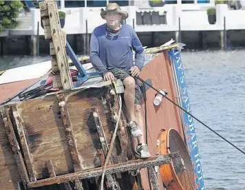  ?? JOE CAVARETTA/SOUTH FLORIDA SUN SENTINEL ?? Jeremy Lycke, owner of Jay’s Sandbar Food Boat, works on the demolition of the floating restaurant Wednesday in Fort Lauderdale. The popular food shop sank in the Intracoast­al Waterway on Sunday after one of its pontoons blew out.