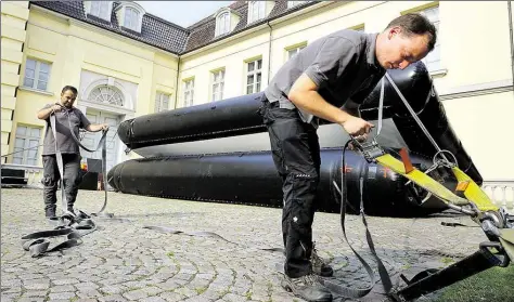  ?? BILD: ROBERT OTTO-MOOG ?? Aufblasbar­e Leinwand: Zwei Techniker bereiten im Schlosshof das Open-Air-Kino vor.