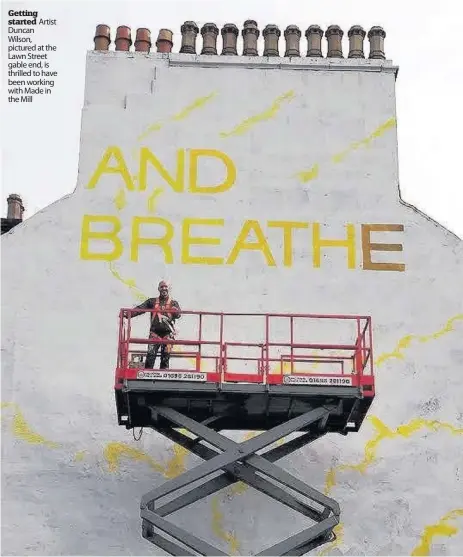  ??  ?? Getting started Artist Duncan Wilson, pictured at the Lawn Street gable end, is thrilled to have been working with Made in the Mill