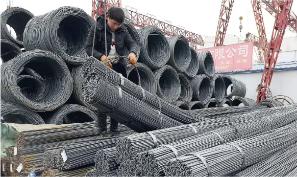  ?? FILE ?? A worker loads steel products on to a vehicle at a steel market in Fuyang in central China’s Anhui province on Friday, March 2. China has expressed “grave concern” about a US trade policy report that pledges to pressure Beijing with tariffs.