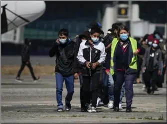  ?? MOISES CASTILLO — THE ASSOCIATED PRESS ?? Unaccompan­ied Guatemalan children who were deported from Mexico, deplane at La Aurora Internatio­nal Airport, in Guatemala City on Feb. 7. The children were stopped