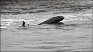  ?? MARSHALL GORBY / STAFF ?? A capsized boat was found stuck on a dam Monday in the Great Miami River near the area of Arbor Boulevard and East River Road in Moraine. Fire officials had not determined if anyone was inside.