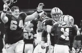  ?? Jed Jacobsohn / Getty Images ?? Garrett Hartley is mobbed by New Orleans teammates after his game-winning 40-yard field goal beat Minnesota for the NFC championsh­ip on Jan. 24, 2010.