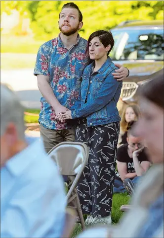  ?? SARAH GORDON/THE DAY ?? Jeff Lewis holds his wife Lisa, of Stonington, as the bell is rung during a vigil and call to action at the First Congregati­onal Church of Old Lyme on Sunday.