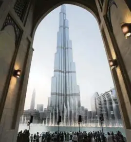  ?? AP Photo ?? With the Burj Khalifa tower in the background, tourists and visitors watch and take photos of the Dubai Fountain in Dubai, United Arab Emirates.