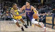  ?? DOUG MCSCHOOLER / AP ?? Phoenix Suns guard Devin Booker (1) drives against Indiana Pacers guard Bennedict Mathurin (00) during the second half of an NBA basketball game in Indianapol­is on Friday.