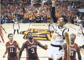  ?? Sue Ogrocki / Associated Press ?? Oklahoma State guard Lindy Waters III dunks in front of Oklahoma’s Trae Young (11), Khadeem Lattin (3) and Kristian Doolittle.