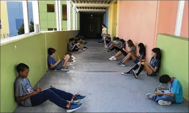  ?? FACEBOOK PHOTO ?? Students at Bak Middle School of the Arts cool down in a hallway after an air-conditioni­ng malfunctio­n caused their classrooms to overheat. There were 40 complaints about the AC during the first five weeks of class.