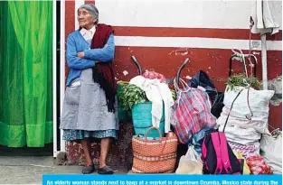  ??  ?? An elderly woman stands next to bags at a market in downtown Ozumba, Mexico state during the outbreak of the novel coronaviru­s. —AFP