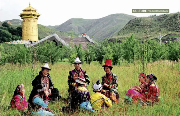  ??  ?? Du Xiuying and Du Xiulan teach children Yugur folk songs on the vast grassland.