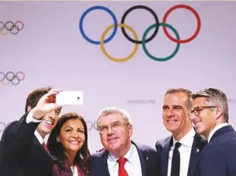  ?? Reuters ?? From left: Tony Estanguet, Anne Hidalgo, Thomas Bach, Eric Garcetti and Casey Wasserman pose for a selfie during a press conference in Lima, Peru.