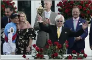  ?? JEFF ROBERSON — THE ASSOCIATED PRESS ?? Jockey John Velazquez, left, watches as trainer Bob Baffert holds up the winner’s trophy after their victory with Medina Spirit in the Kentucky Derby on May 1at Churchill Downs in Louisville, Ky.