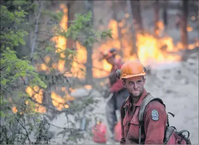  ?? CP PHOTO ?? A B.C. Wildfire Service firefighte­r looks on while conducting a controlled burn to help prevent the Finlay Creek wildfire from spreading near Peachland, B.C., on Thursday, Sept. 7.
