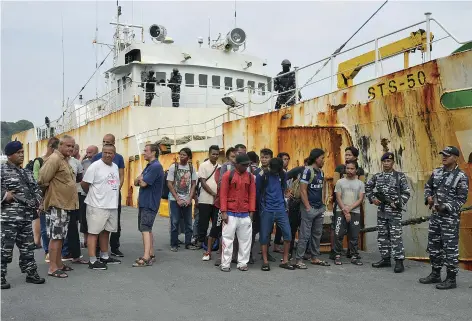  ??  ?? The captured crew of the STS50 surrounded by Indonesian soldiers. The ship’s 600 gill nets could cover 18 miles and enable its workers to haul in more than $6 million of toothfish in a single trip.