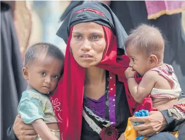  ?? AP ?? Rohingya Muslim woman, Rukaya Begum, who crossed over from Myanmar into Bangladesh, holds her son Mahbubur Rehman, left and her daughter Rehana Bibi, after the government moved them to newly allocated refugee camp areas, near Kutupalong, Bangladesh.