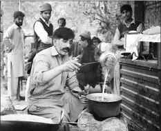  ??  ?? Malik Zafar Iqbal, who runs an union ‘Associatio­n of Kidney Sellers’ (AKS), makes tea for customers at his stall in the town of Kot Momin.