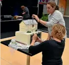  ??  ?? Jill Myers, rear, and Mellissa Culpan put the finishing touches to the celebratio­n cake, a model of the old office block and school gates.