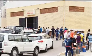  ?? Photos by Rizk Taufiq and Iehab Qartal ?? Top: Large number of people seen in one of the supermarke­ts, and (above) people line up to buy gas
cylinders.