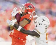  ?? Ian Maule/Associated Press ?? Oklahoma State's Bryson Green catches a pass over Texas' D'Shawn Jamison during the first quarter.