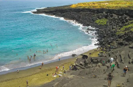  ?? Marco Garcia / Associated Press 2014 ?? The green sand of Papakolea beach in Hawaii is made of olivine, a volcanic rock that removes carbon dioxide from seawater.