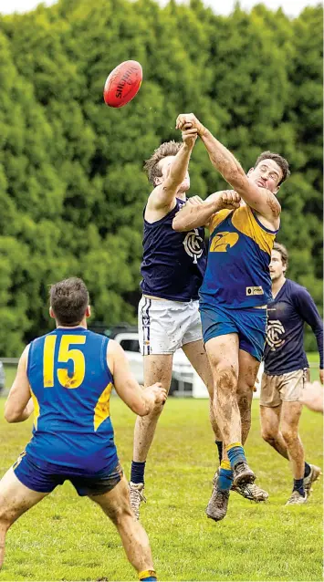  ?? The ball by Catani’s Lachlan Photograph­s: Fearghus Browne ?? Ellinbank’s Adamson Cook and Catani’s William Geyer jump for the ball in this hit out in the foAbove: urth quarter.
Left: Ellinbank’s Andrew Quirk is held back from
Free in the second quarter of the seniors game.