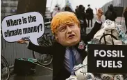  ?? Scott Heppell / Associated Press ?? A protester wears a caricature of British Prime Minister Boris Johnson at a Nov. 12 Glasgow rally.