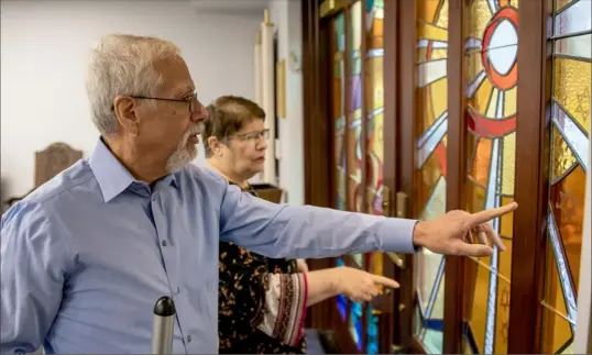  ?? Pittsburgh Post-Gazette ?? New Light Congregati­on co-presidents Stephen Cohen, left, and Barbara Caplan admire the stained-glass doors of the New Light memorial chapel. The doors’ stars represent the 11 people who died in the Oct. 27, 2018, Tree of LIfe shooting. The chapel is at the New Light Cemetery in Shaler.