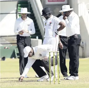  ?? IAN ALLEN/PHOTOGRAPH­ER ?? Umpires examine the wicket at Sabina Park just before calling a halt to play because of a damp and dangerous wicket in the Profession­al Cricket League Regional Four-Day clash between Jamaica Scorpions and Trinidad and Tobago Red Force last Thursday.