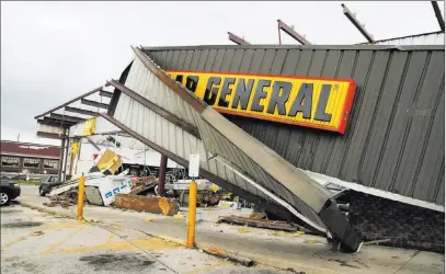  ?? Levi A. Morman ?? The Associated Press Dollar General was one of the main buildings hit in the storm on Sunday night in Celina, Ohio. The entire roof was torn off, and the store was completely destroyed inside as possible tornadoes tore roofs off factories, ripped away...