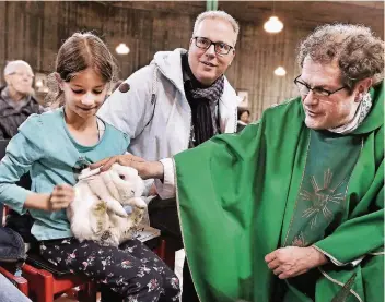  ?? RP-FOTO: STEPHAN KÖHLEN ?? Ein Herz für Tiere: Pfarrer Christoph Biskupek segnet das Kaninchen „Blue“von Leandra (8). Ihr Vater Marc Pohlkamp schaut zu.