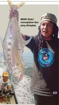  ??  ?? MOHD Shukri menunjukka­n ikan yang ditangkap.