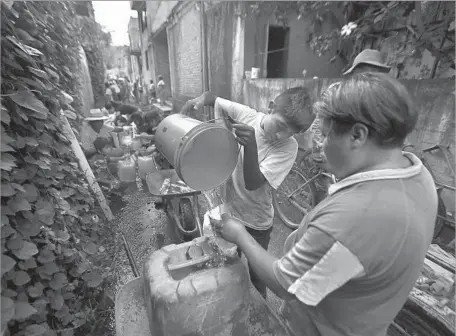  ?? Eduardo Verdugo Associated Press ?? RESIDENTS of San Gregorio Atlapulco collect water after Mexico’s Sept. 19 quake. “The authoritie­s abandoned us,” one man said.