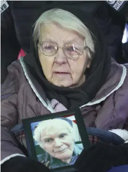  ??  ?? REMEMBERIN­G A FRIEND: Doris Sevigny, 91, holds a picture of her close friend Army veteran James McCue during his funeral.