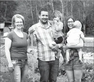  ?? SUSAN MCIVER/Special to The Herald ?? Rob Holland holding Krin, 3, and wife Holly with Sadie, 1. The couple owns Hands &amp; Hearts Acres on VLA Road in Cawston. Lisa Holland, left, came from Ontario to give her brother a hand with the farm for the summer.