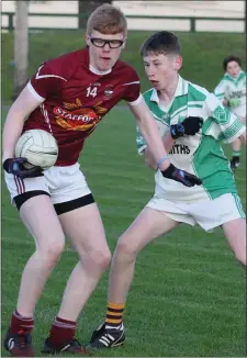  ??  ?? Ross Arnold of Castletown holds off the challenge of Crossabeg-Ballymurn’s Conor Bernard.