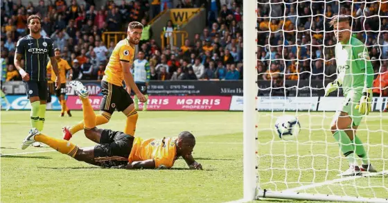  ?? —Reuters ?? Fierce action: Wolverhamp­ton’s Willy Boly scores their first goal against Manchester City in a Premier League match yesterday.