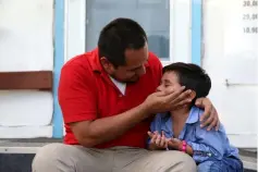  ??  ?? Walter Armando Jimenez Melendez, an asylum seeker from El Salvador, arrives with his four year-old son Jeremy at La Posada Providenci­a shelter in San Benito,Texas, US, shortly after he said they were reunited following separation since late May while...