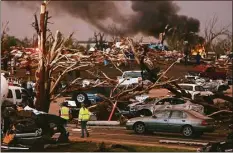  ?? Associated Press ?? In this May 22, 2011 file photo, emergency personnel walk through a severely damaged neighborho­od after a tornado hit Joplin, Mo.