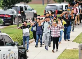  ?? Vernon Bryant / The Dallas Morning News ?? Students and faculty exit a building with their hands up after a shooting at North Lake College in Irving on Wednesday. The shooting left two dead including the shooter.