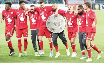  ?? — Reuters ?? Bayern Munich’s players celebrate after the match after winning the Bundesliga.