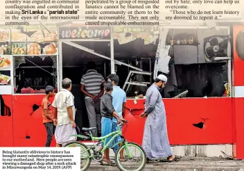  ?? (AFP) ?? Being blatantly oblivious to history has brought many catastroph­ic consequenc­es to our motherland. Here people are seen viewing a damaged shop after a mob attack in Minuwangod­a on May 14, 2019.