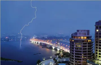  ?? MEGHAN MCCARTHY / PALM BEACH DAILY NEWS ?? Lightning strikes the Intracoast­al Waterway north of the Royal Park Bridge on Wednesday night in West Palm Beach. A fireworks company executive said rain doesn’t hamper the setting off of fireworks.