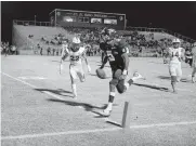  ?? [SARAH PHIPPS/ THE OKLAHOMAN] ?? El Reno's Dorian Plumley scores a touchdown in front of Piedmont's Jacob Anglin during last Friday's Class 5A playoff game in El Reno.