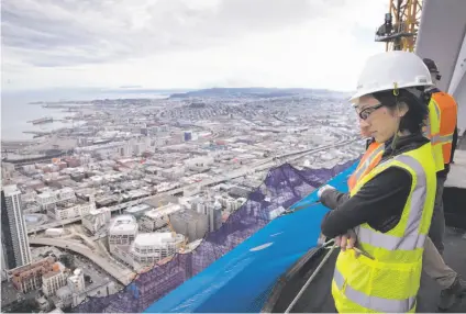  ?? Photos by Carlos Avila Gonzalez / The Chronicle ?? Mirjam Link of Boston Properties looks out from Salesforce Tower’s top floor toward the Bay Bridge. The building has already surpassed the 853-foot Transameri­ca Pyramid, below with Marin County in the background, as the city’s tallest.