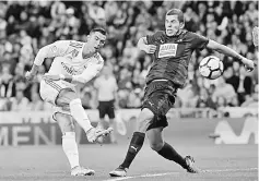  ??  ?? Ronaldo (left) kicks the ball past Eibar’s Spanish midfielder Christian Rivera during the Spanish league football match at the Santiago Bernabeu stadium in Madrid. — AFP photo