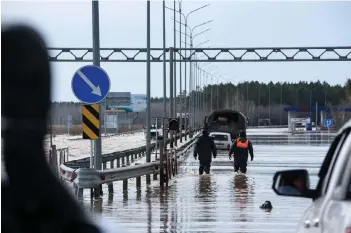  ?? — AFP photo ?? Cars move through a flooded part of a road in the city of Petropavl in northern Kazakhstan close to the border with Russia.