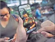  ?? REUTERS ?? A (blue) Pokemon seen on a phone screen next to a woman as a man plays Pokemon Go in New York