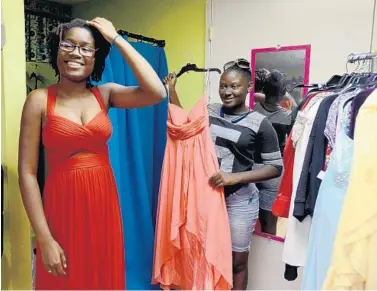  ?? MARIA LORENZINO/STAFF PHOTOGRAPH­ER ?? Moesha Johnson, left, 19, and Kandy Johnson, 18, try on prom dresses at Cool Clothes Closet in Delray Beach.